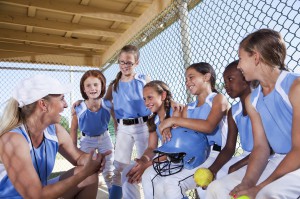 Youth sports coach working with young softball players - Trusted Coaches