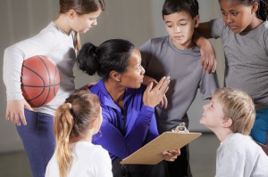 Youth sports coach working with young basketball players - Trusted Coaches
