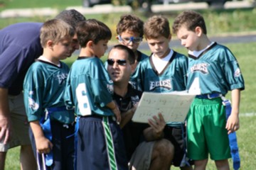 Youth sports coach working with young soccer players - Trusted Coaches