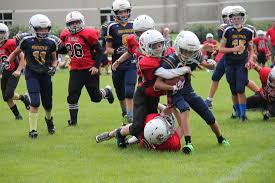 Youth football game - players tackling one another